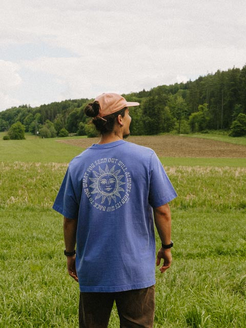 Mann trägt das GOOD ENERGY Oversized T-Shirt in Lila, Größe L – großer Sonnen-Print auf dem Rücken, handbedruckt im Siebdruck