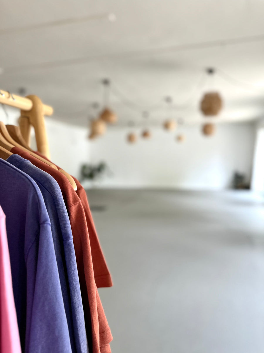 Kleiderstange mit B·WARNA Shirts im Kursraum des NALU Studio Traunstein