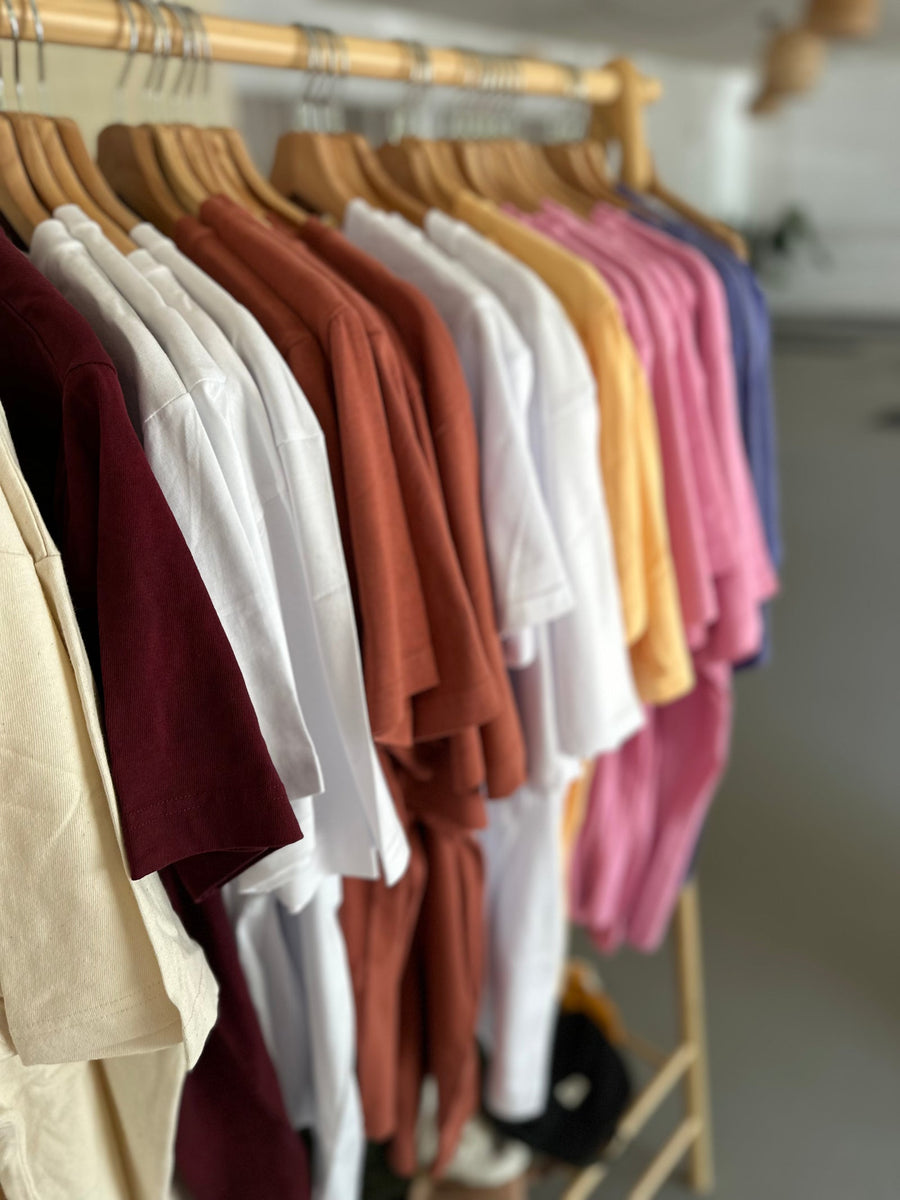 Handgefärbte B·WARNA T-Shirts in verschiedenen Farben an der Kleiderstange